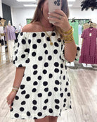 Woman wearing a polka dot dress in a store setting