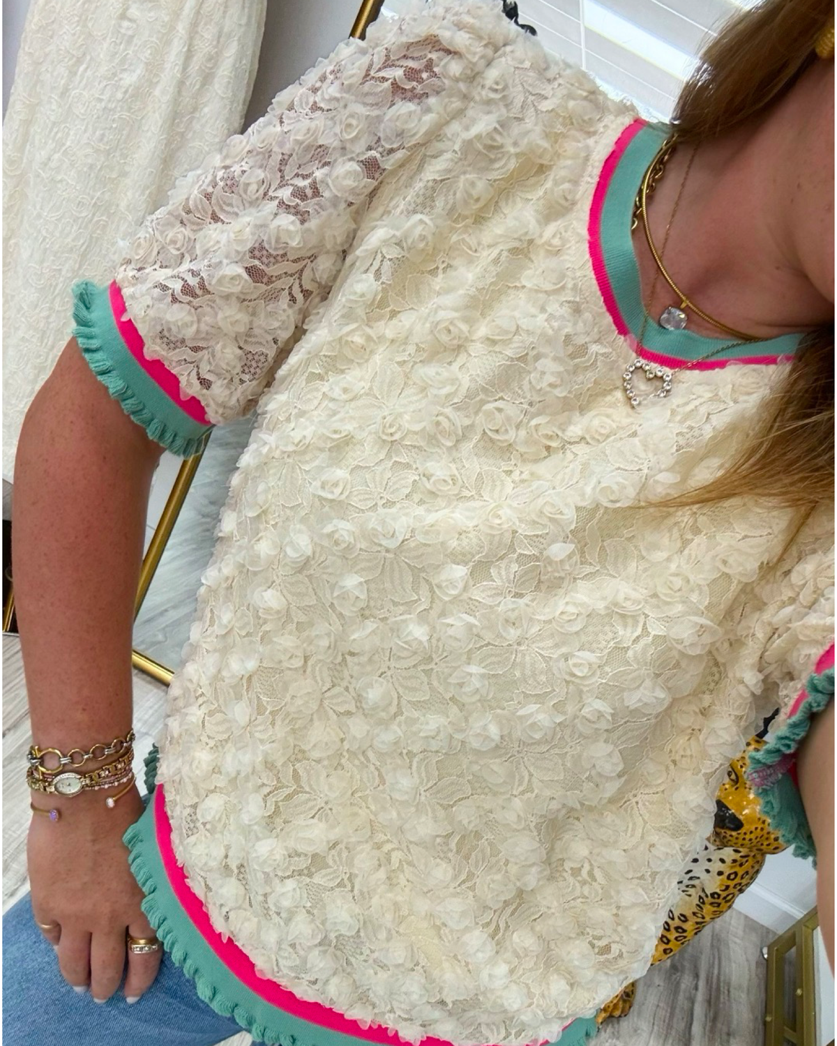 Close-up of a person wearing a white lace dress with colorful trim.